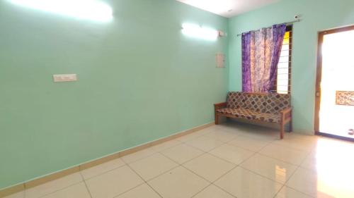 a living room with a couch and a window at Uddish Residency in Virāmpattinam