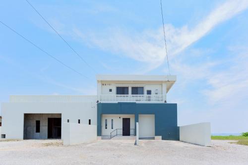 a white and blue building with a sky at Cliff Sky in Miyako Island