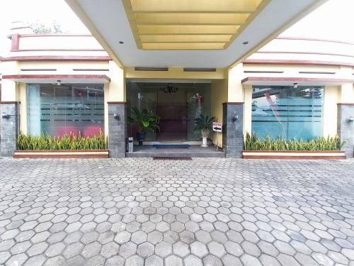 a front door of a building with plants at Hotel Palem Sari Syariah Batu RedPartner in Punten