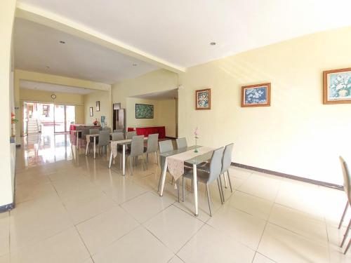 a dining room with a table and chairs at Hotel Palem Sari Syariah Batu RedPartner in Punten