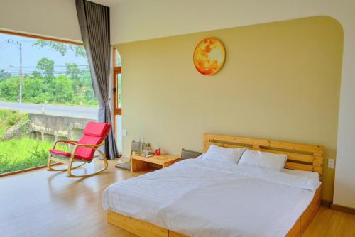 ダナンにあるDu Nhiên farm villa- Venuestayのベッドルーム(白いベッド1台、赤い椅子付)