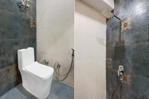 a bathroom with a toilet and a shower at Hotel O The Skies in Juhi Bari