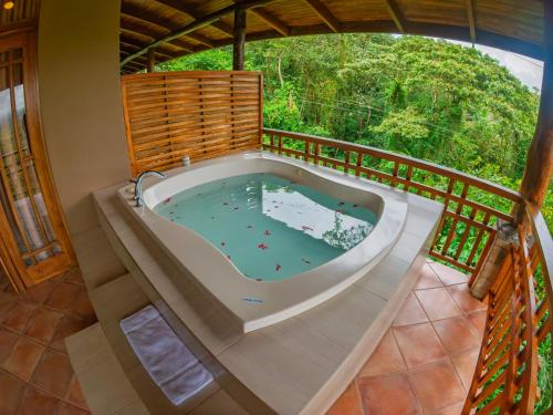 a jacuzzi tub on the deck of a house at Lost Iguana Resort and Spa in Fortuna