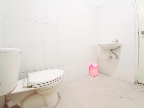 a white bathroom with a toilet and a sink at Hotel Palem Sari Syariah Batu RedPartner in Punten