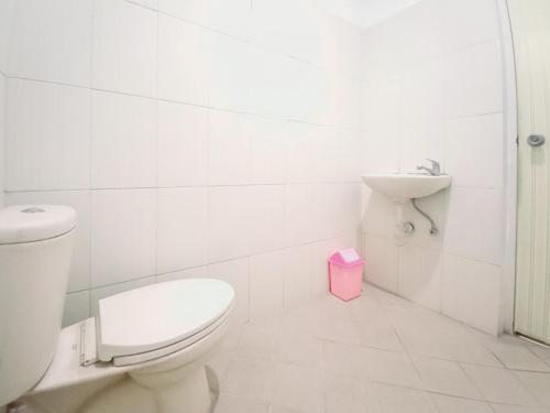 a white bathroom with a toilet and a sink at Hotel Palem Sari Syariah Batu RedPartner in Punten