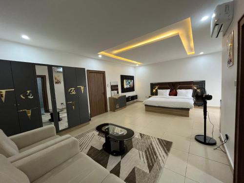 a large bedroom with a bed and a couch at Fancy Suites and Apartments Ltd in Abuja