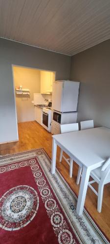 ein Wohnzimmer mit einem weißen Tisch und eine Küche in der Unterkunft Sackleninkatu in Pori