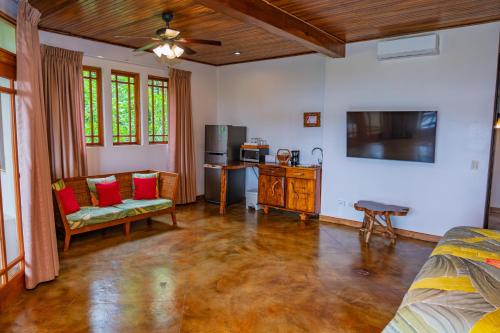 a living room with a bed and a tv at Lost Iguana Resort and Spa in Fortuna