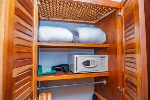 a kitchen with a microwave and some towels at Lost Iguana Resort and Spa in Fortuna