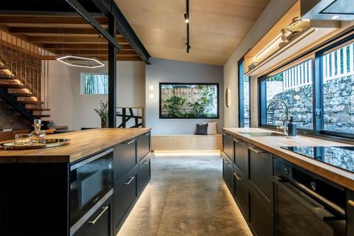 una cocina con armarios negros y una encimera grande en Luxury Historic Landmark Holdgates Cottage, en Brisbane