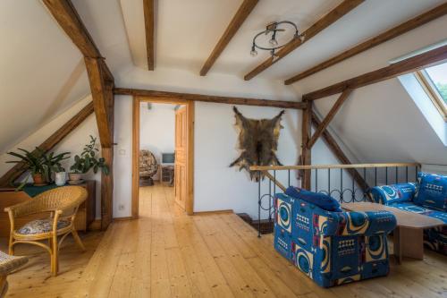 a living room with a loft with wooden beams at Penzion U Dračice in Nová Bystřice