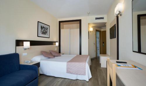 a hotel room with a bed and a couch at Sandos Griego in Torremolinos
