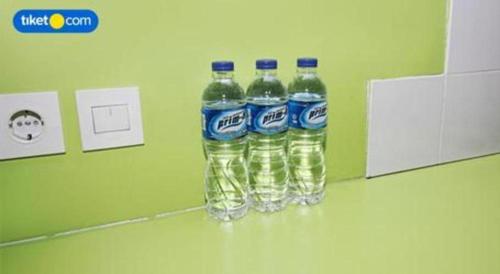 three bottles of bottled water sitting on a counter at Griya Jogja Hotel in Yogyakarta
