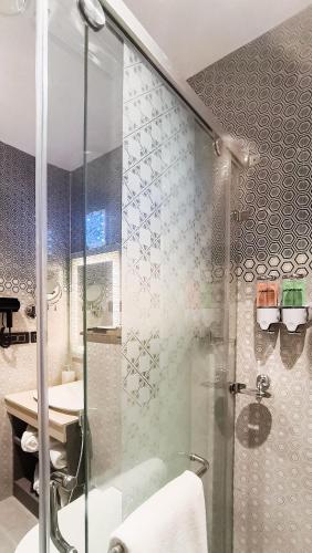 a bathroom with a shower and a sink at The Meriton in New Delhi
