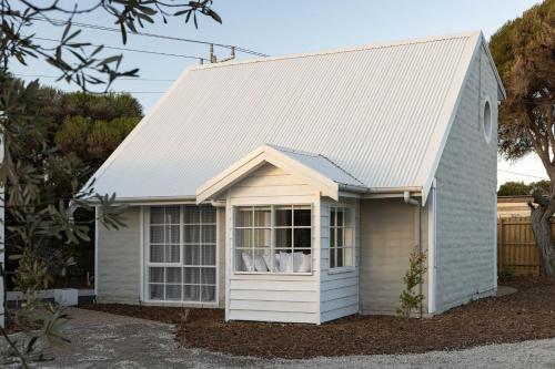 a small white house with a white roof at PI Hot Springs Retreat1 in Surf Beach