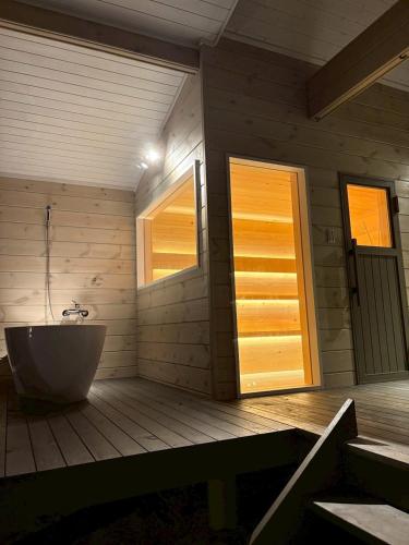 a bathroom with a tub and a window and a door at Second House kukka in Naganohara