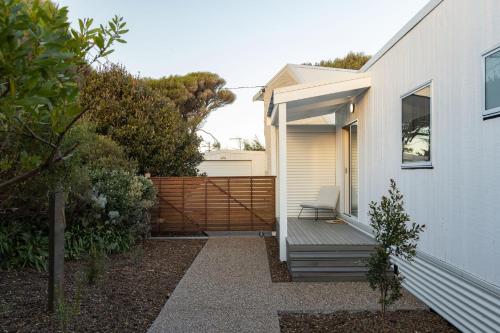 a house with a bench next to a fence at PI Hot Springs Retreat1 in Surf Beach