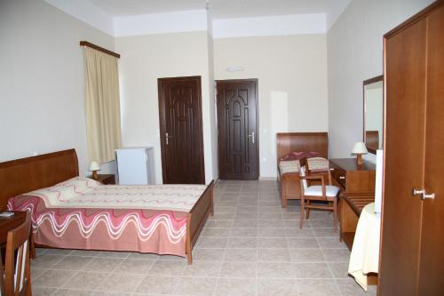 a hotel room with a bed and a desk and a room at Calypso Apartments in Vathi, Ithaka