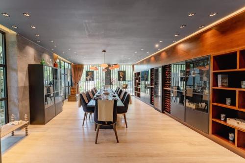 een lange eetkamer met een tafel en stoelen bij Galeria Privada - Tulum Hidden Masterpiece in Tulum