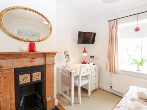 a room with a desk and a mirror and a table at Driftwood Cottage in Heacham