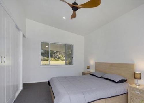 a bedroom with a bed and a ceiling fan at Dreamtime 5 Ward St Hat Head -No Sheets or Towels provided in Hat Head