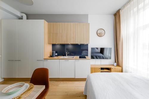 a bedroom with a bed and a table and a kitchen at Stylish Apartment near Old Town in Tallinn