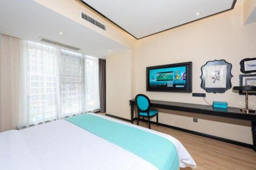 a bedroom with a bed and a desk and a tv at Xana Hotelle Chengdou Xindu Sanhechang Metro Station in Chengdu
