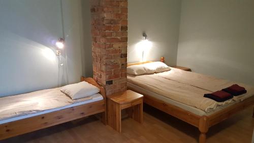 two beds in a room with a brick wall at Konse Motel and Caravan Camping in Pärnu