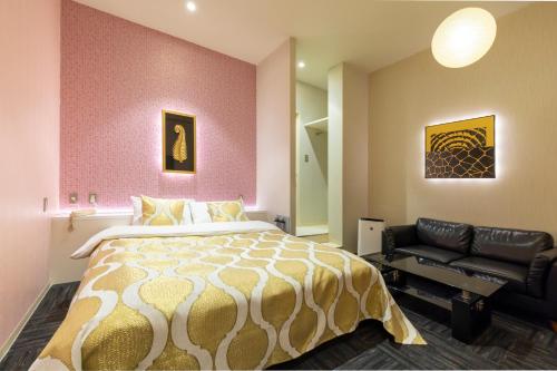 a bedroom with a large bed and a couch at ホテルパサディナ11郡山 in Koriyama