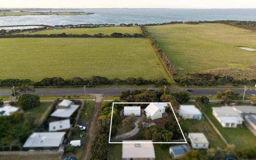 an aerial view of a house with a field and the ocean at Original Beach Retreat1 in Surf Beach