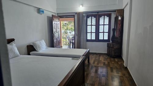 a bedroom with two beds and a window at Lagoon Breeze Resort in Batticaloa