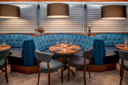 a restaurant with blue booths and tables and chairs at Garryvoe Hotel in Ballycotton