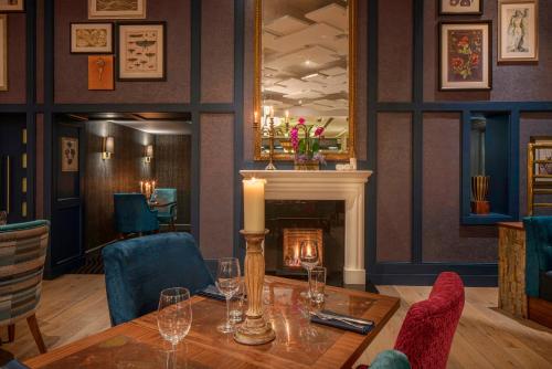 a dining room with a table and a fireplace at Garryvoe Hotel in Ballycotton