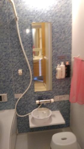a bathroom with a toilet and a mirror and a sink at メゾネットHIRAKU in Izumi-Sano