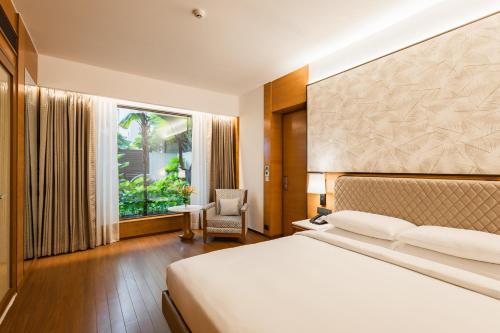 a hotel room with a bed and a window at Hyatt Pune in Pune