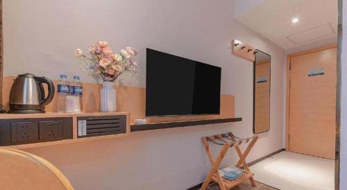 a living room with a television on a wall at City Comfort Inn Liuzhou High-speed Railway Station in Liuzhou
