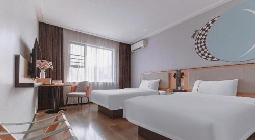 a hotel room with two beds and a mirror at City Comfort Inn Liuzhou High-speed Railway Station in Liuzhou