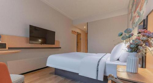 a hotel room with a bed and a tv at City Comfort Inn Liuzhou High-speed Railway Station in Liuzhou