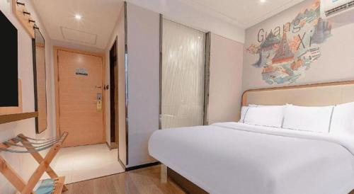 a bedroom with a large white bed and a window at City Comfort Inn Liuzhou High-speed Railway Station in Liuzhou