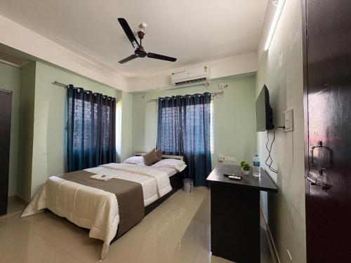 a bedroom with a bed and a ceiling fan at DXK Villa Homestay in Guwahati