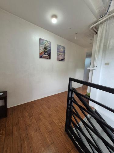 a room with three paintings on a wall and a wooden floor at Alec Lodge in Coron