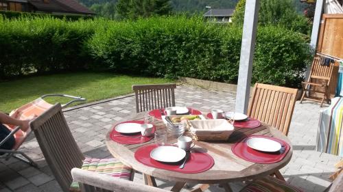 a wooden table with red and white plates on it at Haus Jelini in Schnepfau