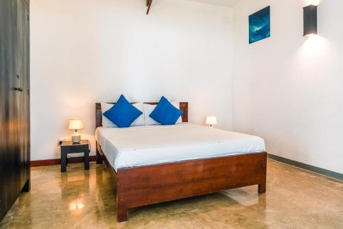 Un dormitorio con una cama con almohadas azules. en Marleys Beach House, en Talpe