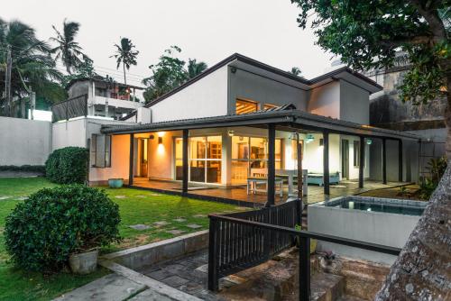 a modern house with a pool in a yard at Marleys Beach House in Talpe