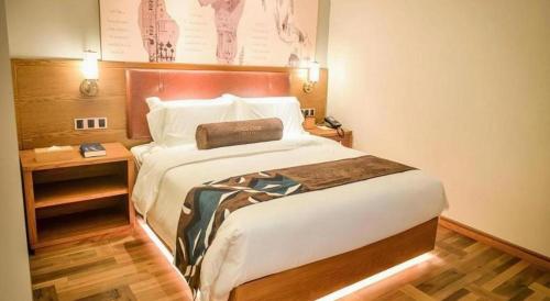 a bedroom with a large bed in a hotel room at James Joyce Coffetel Luoyang Longmen High-speed Railway Station Baolong Plaza in Luoyang