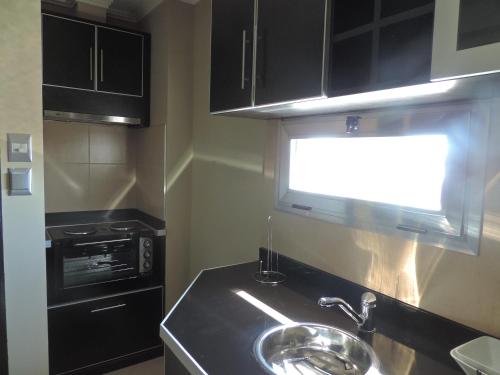 a kitchen with a sink and a window at Apart Belgrano in Posadas