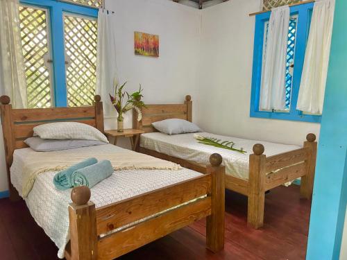 two beds in a room with blue windows at Villas Itaita Beach Cabins in Punta Uva