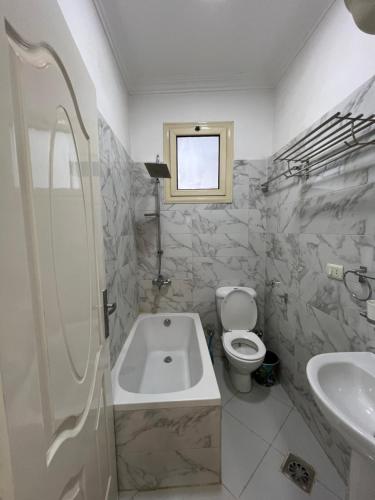 a bathroom with a tub and a toilet and a sink at Roma Apartment LXR in Luxor