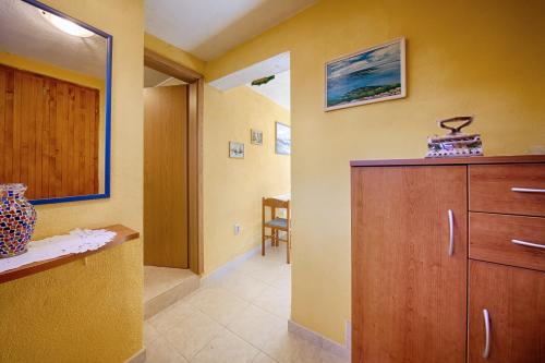 a room with a cabinet and a dining room at Apartments Pol Murvu in Vis