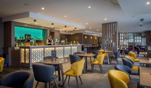 ein Restaurant mit Tischen und Stühlen und eine Bar in der Unterkunft Maldron Hotel Pearse Street in Dublin